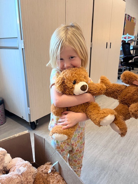 girl hugs teddy bear