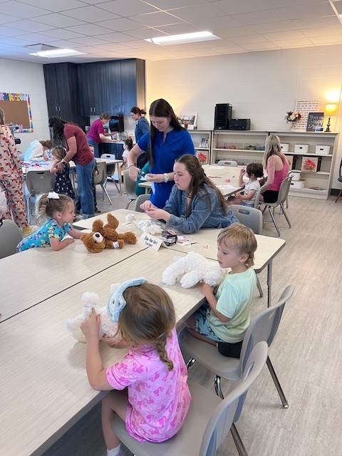 students hold teddy bears