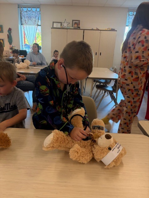 boy plays doctor with teddy bear