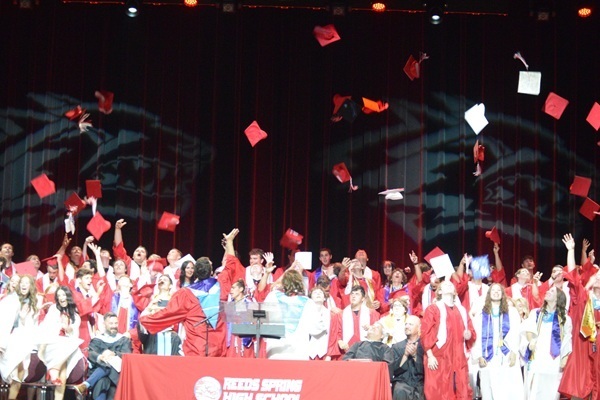 graduates toss caps into the air