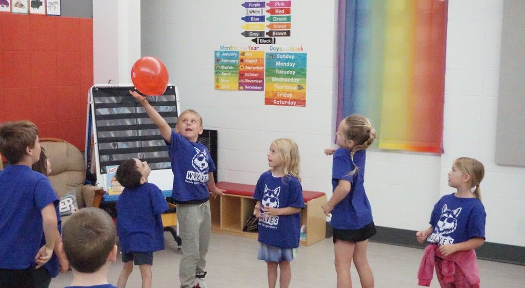 boy taps a balloon into the air
