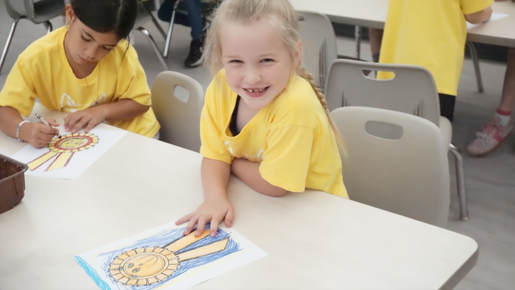 girl smiling while showing off her drawing