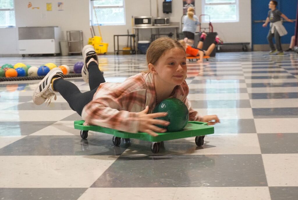 girl riding scooter on belly