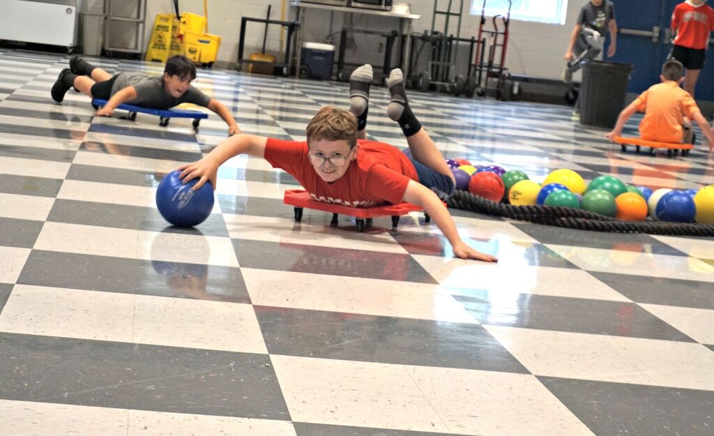 boy rolling on scooter on belly