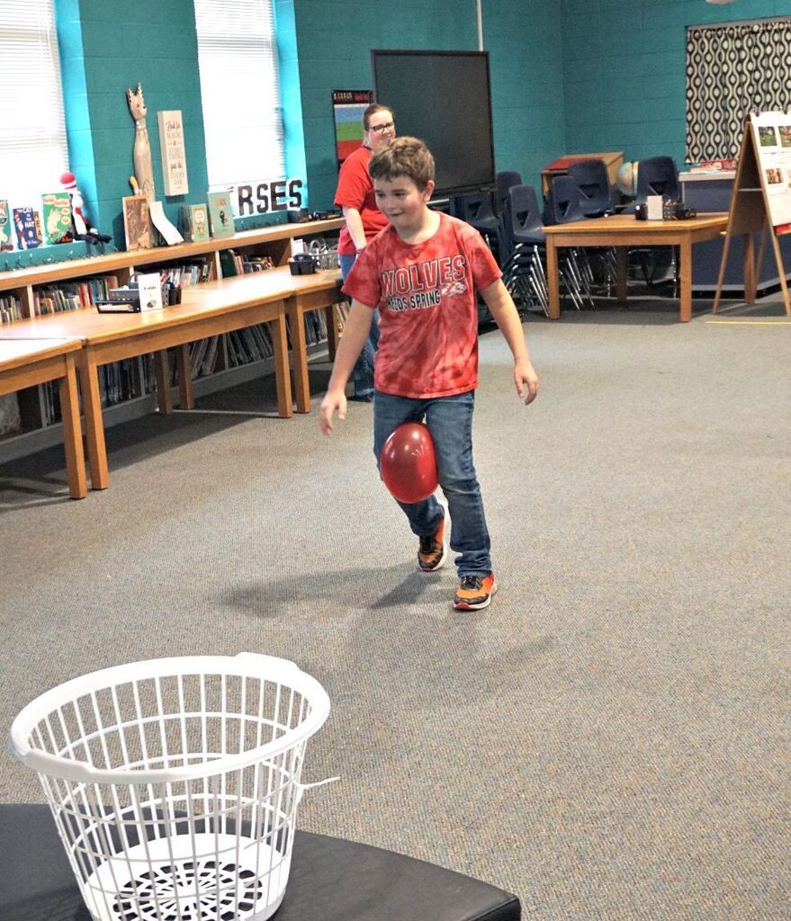 boy hopping with balloon between legs
