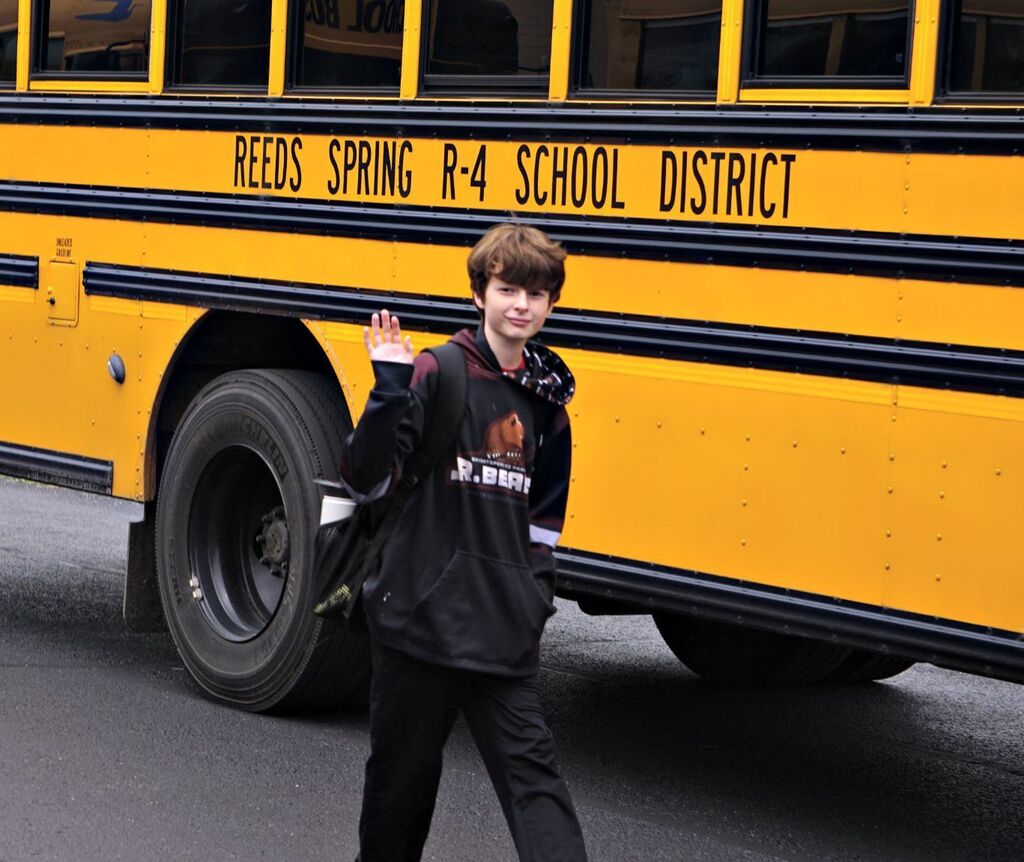 boy waving to camera