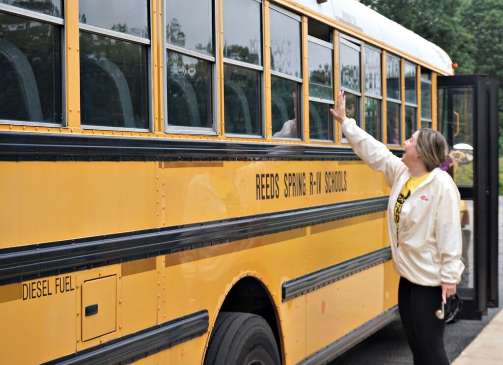 teacher waving to the bus