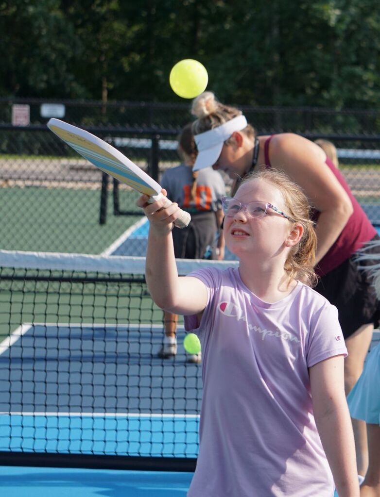 A girl hitting a pickleball