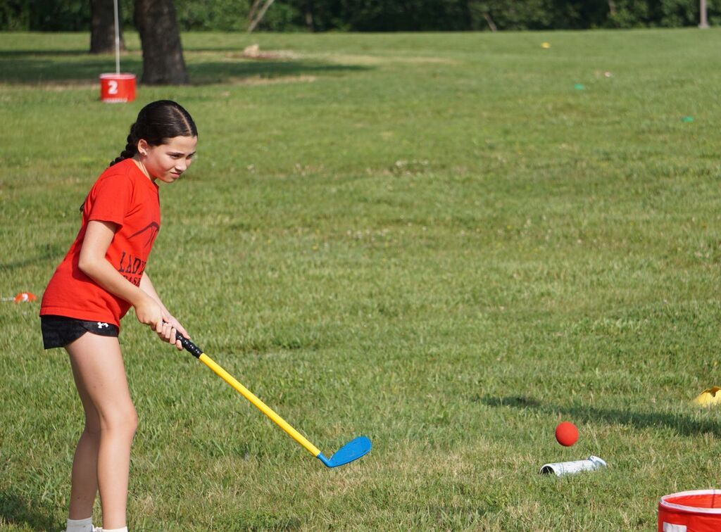 A girl swinging a golf club