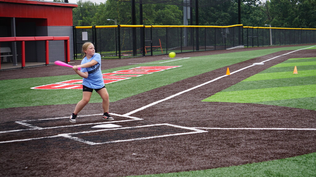 A girl swinging a softball bat
