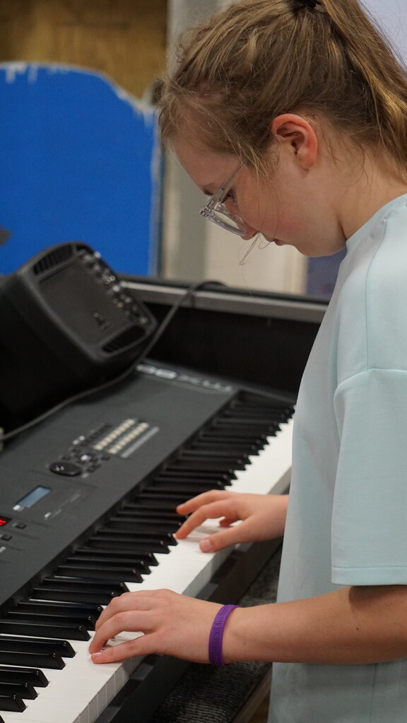Kylie M playing keyboard
