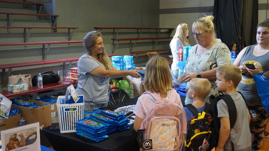 Rotary Club member handing out school supplies.