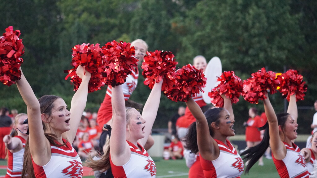 Two cheerleaders with arms in the air