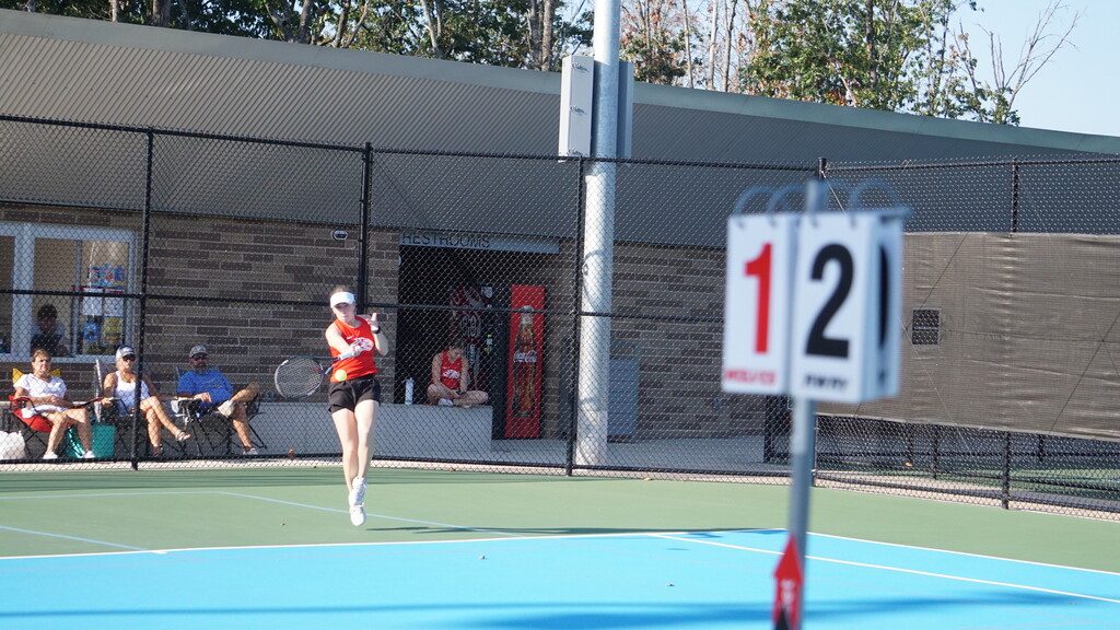 Chloe returns a serve