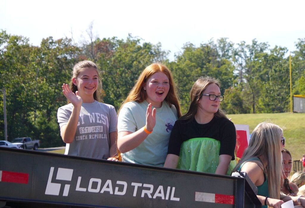 Freshmen volleyball players wave from a float.