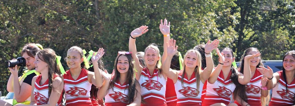 Cheerleaders wave from their float