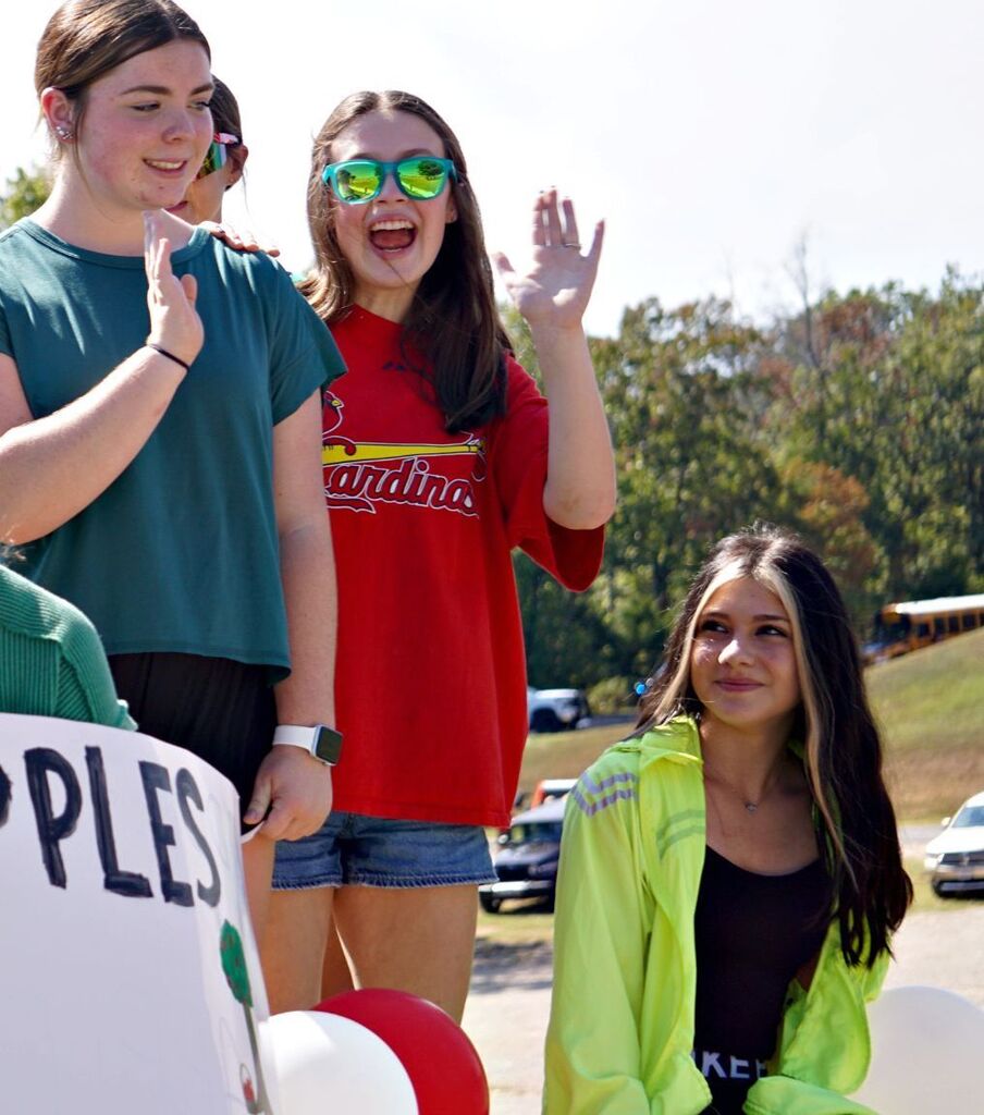 Volleyball players wave from their float