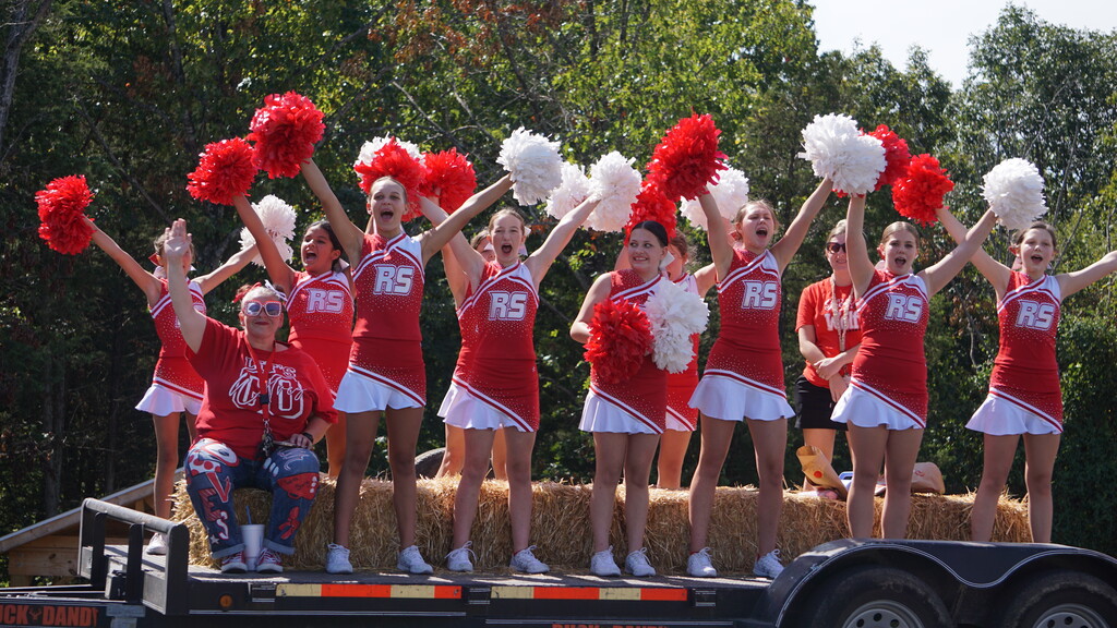 Middle School cheerleaders cheer from a float.