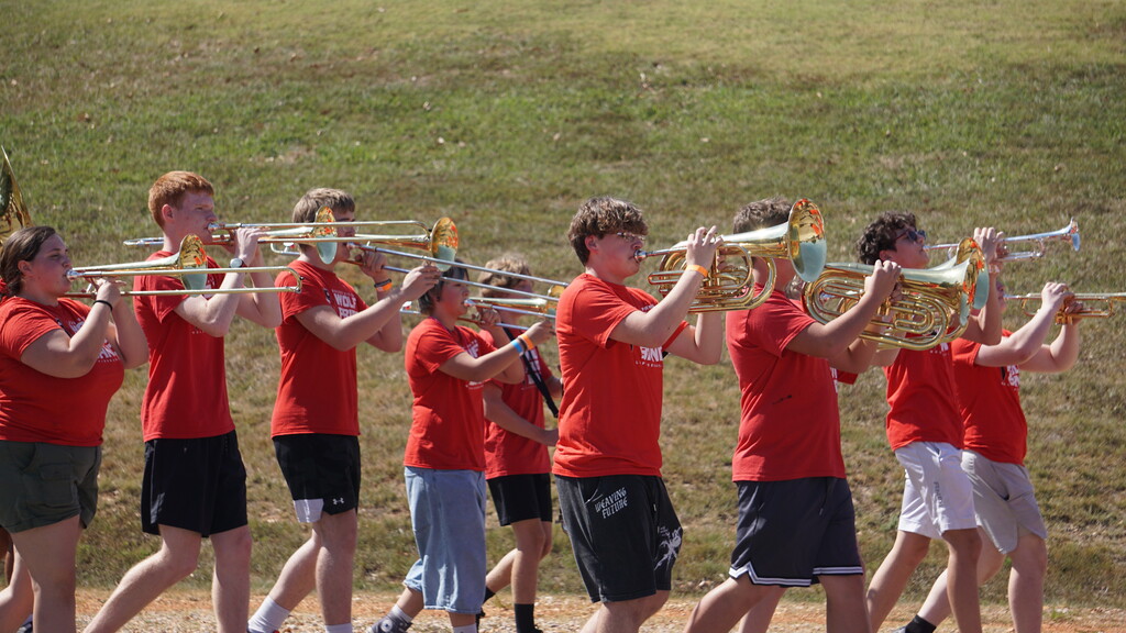 Trombone players march and play