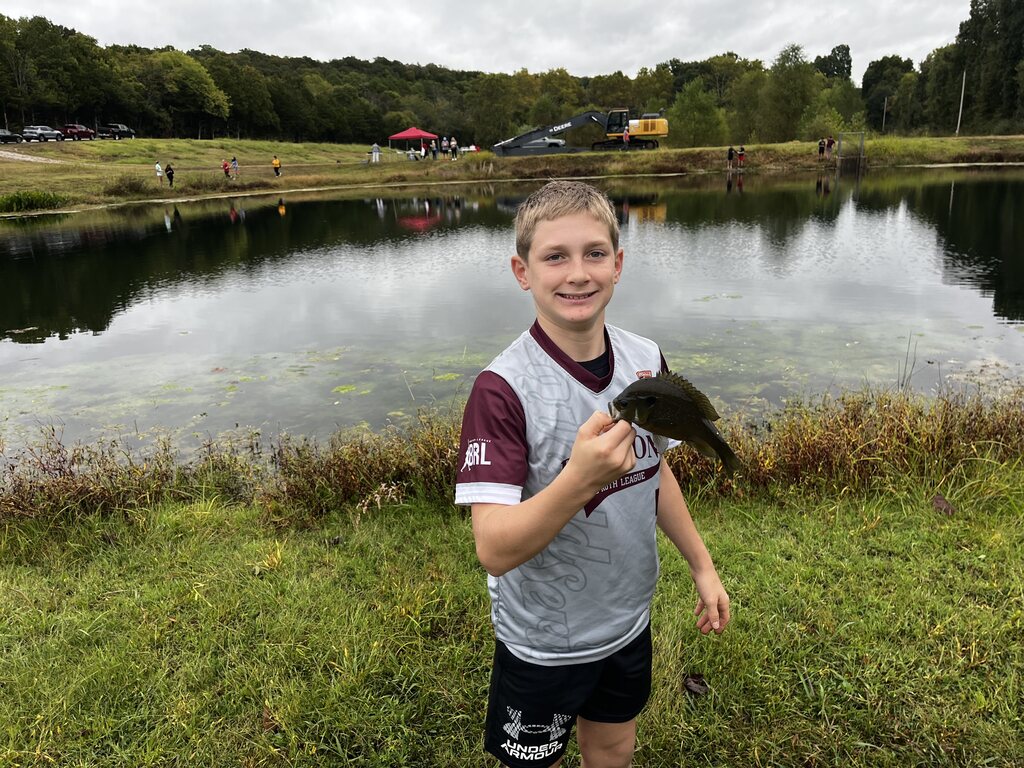 Tate F. shows off fish he caught.