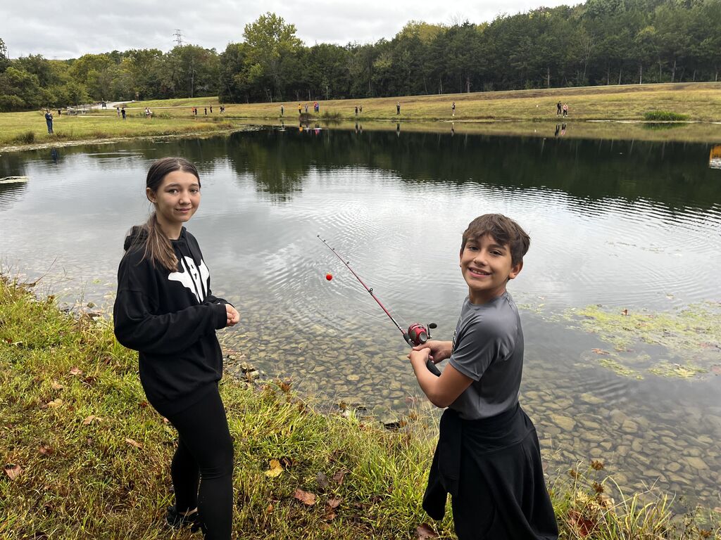 Girl and boy smile while fishing