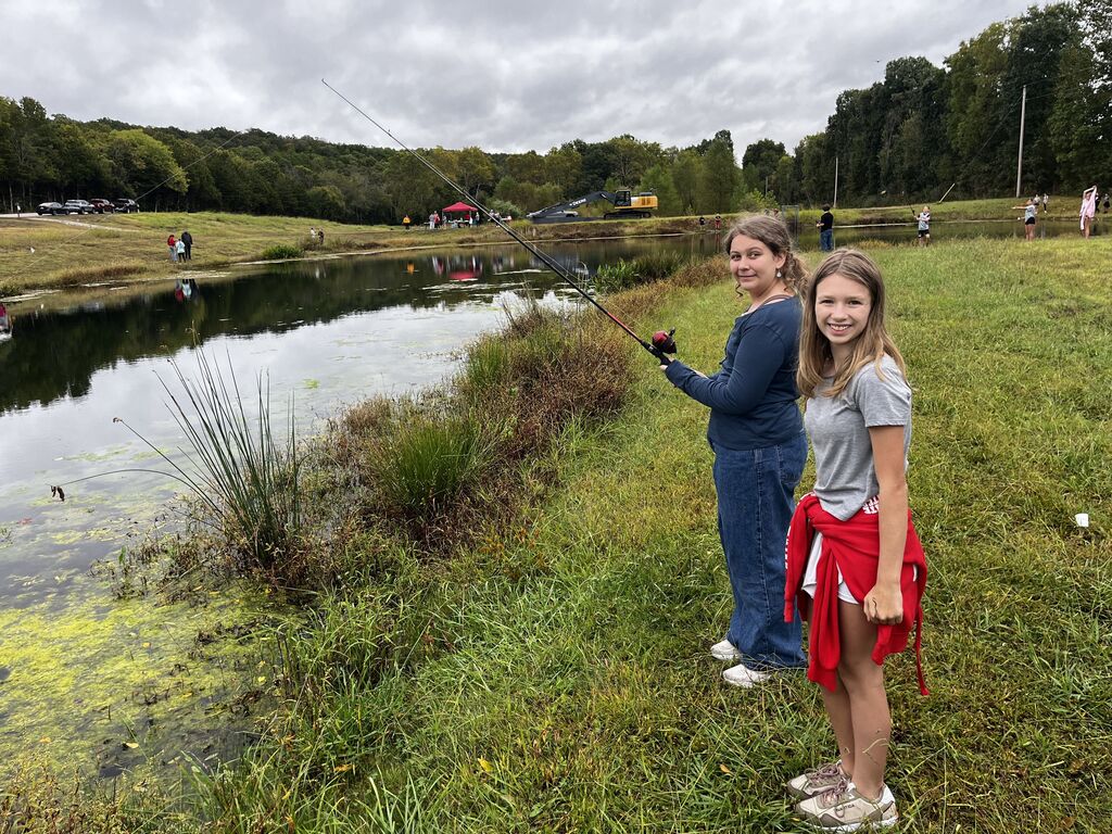 Two girls smile while fishing