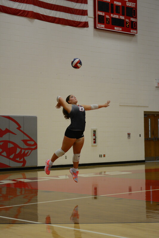 Chloe K. serving volleyball