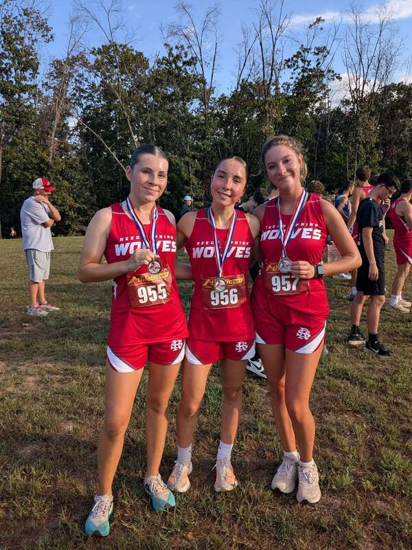 Grace, Anna, and Claire with medals around necks.