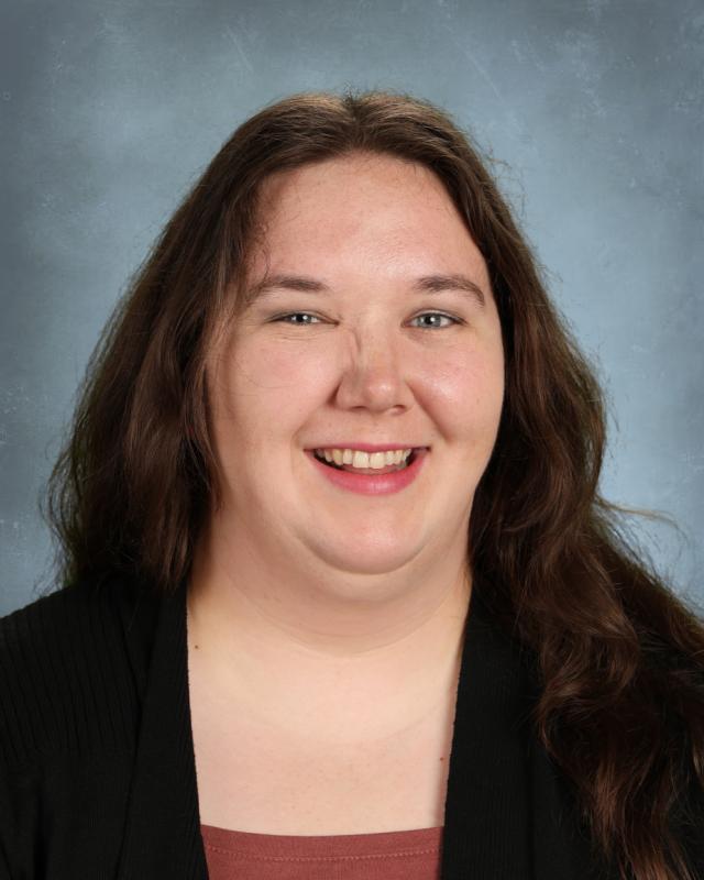 woman in black sweater and brown shirt smiling