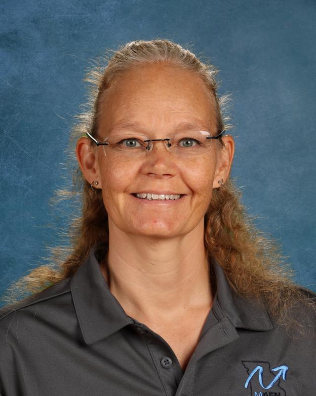 woman in glasses and gray shirt smiling