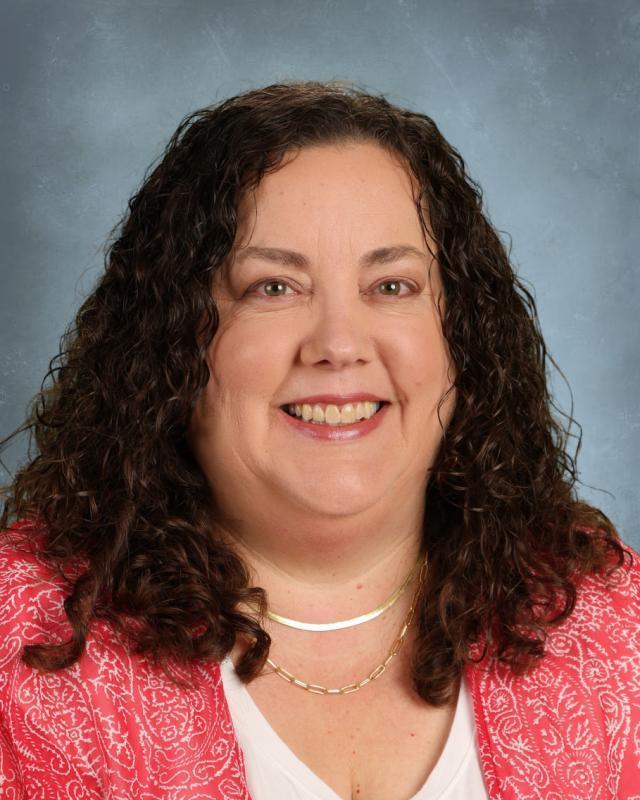 woman with dark curly hair and pink shirt