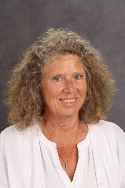 woman with curly brown hair and a white shirt