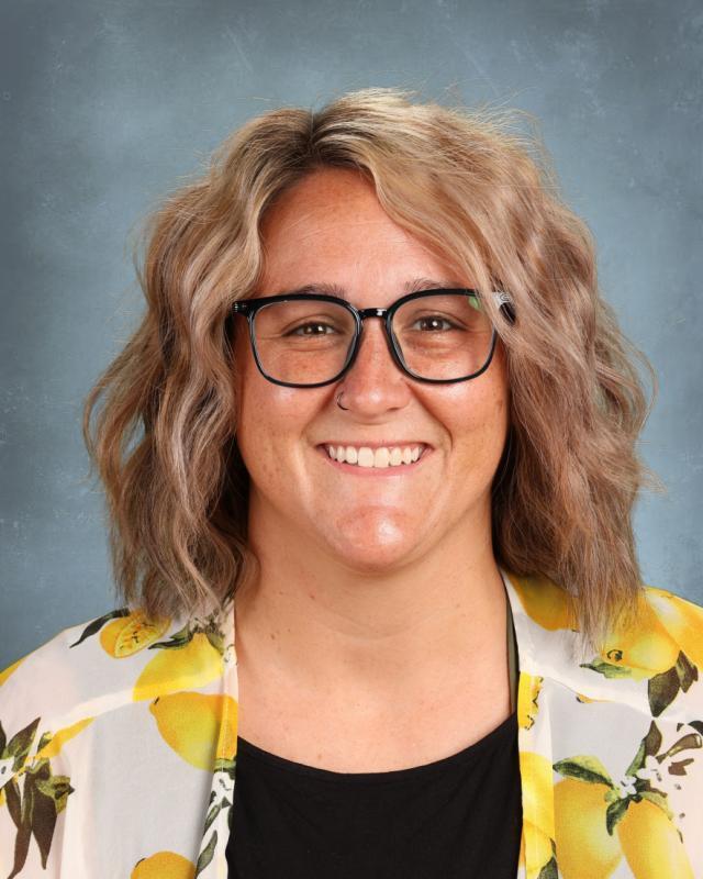 woman with blond hair and glasses wearing yellow shirt