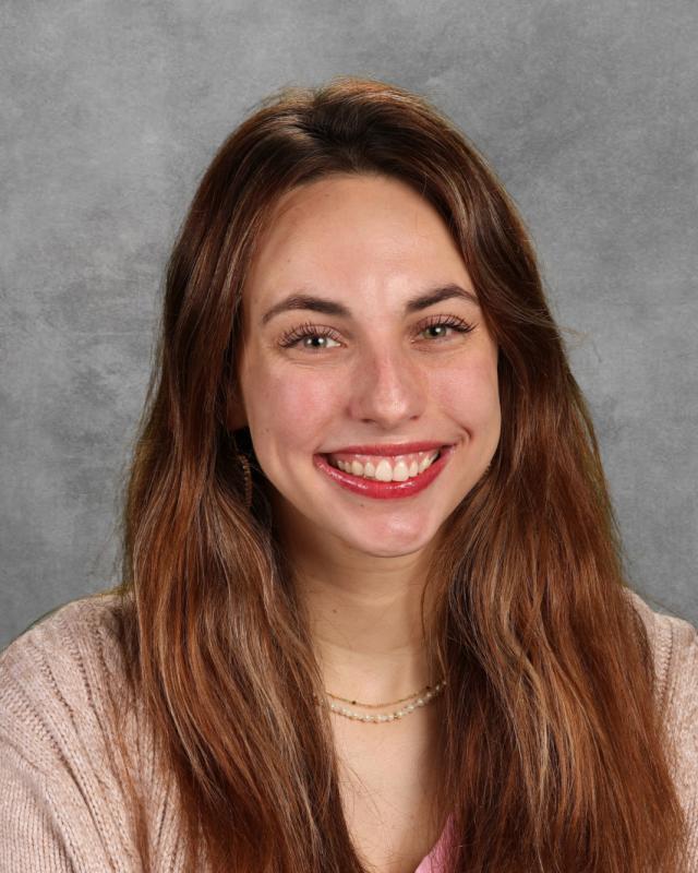 woman with brown hair and tan shirt