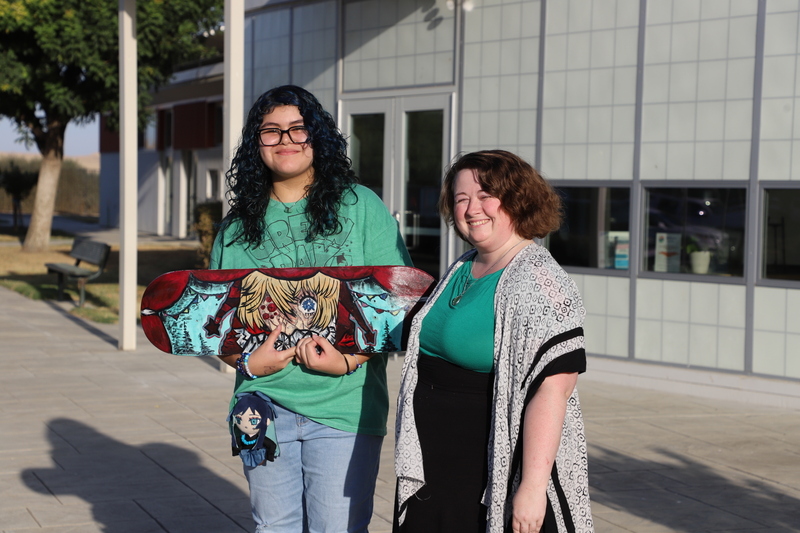 RSMS student C.Ramirez with her art teacher holding up her skateboard art work project