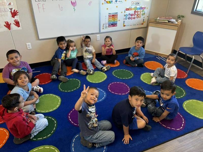 preschool students sitting on mat