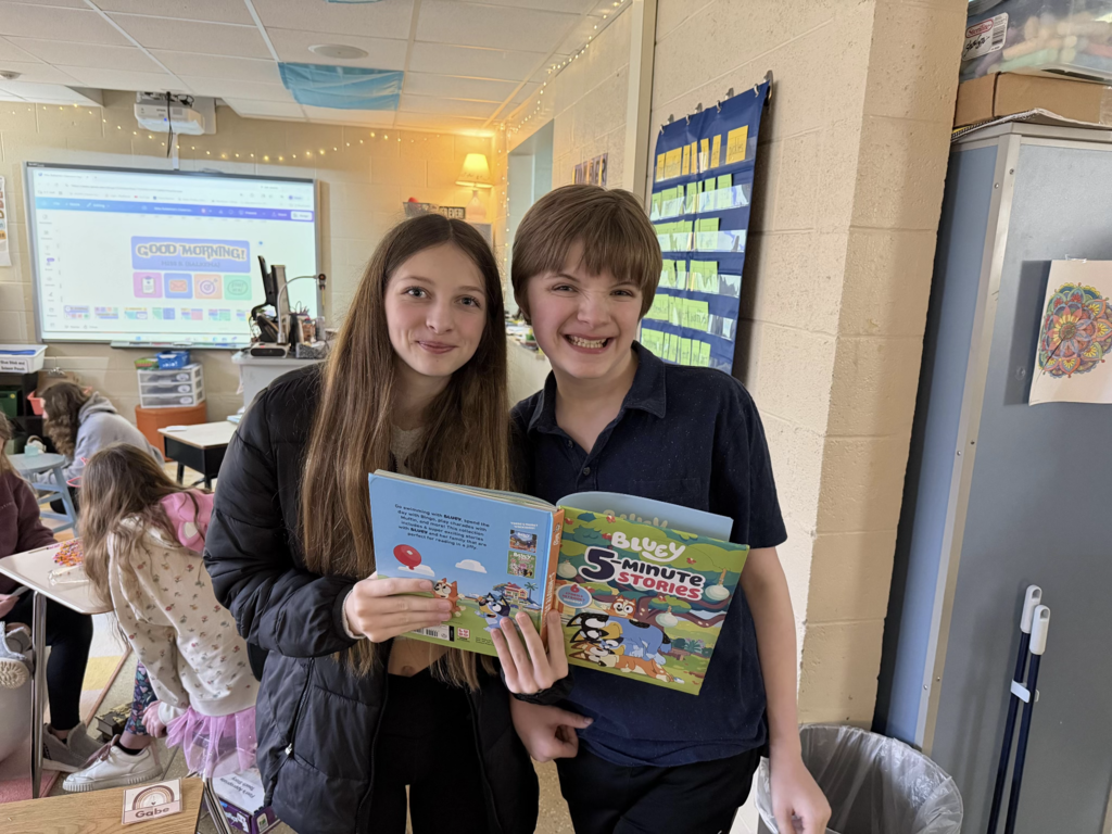Students spend time together reading a book.