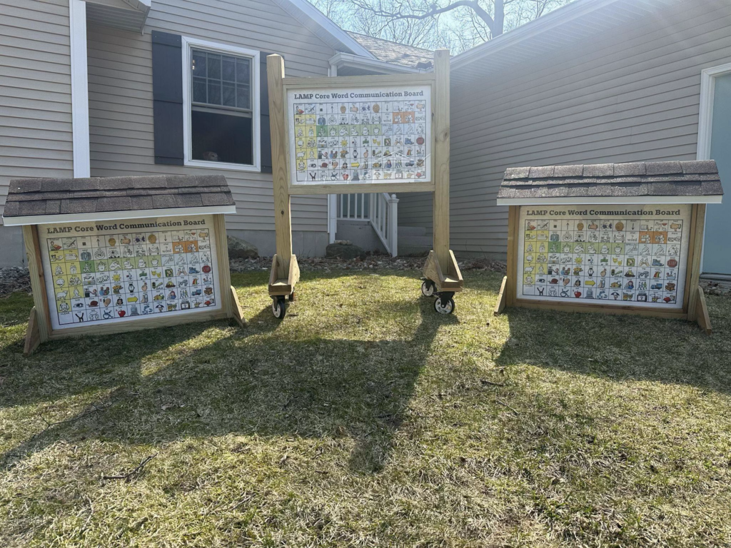 Outdoor communication boards display pictures, symbols, and words that students can use to express their needs and ideas.