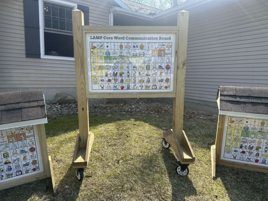 Outdoor communication boards display pictures, symbols, and words that students can use to express their needs and ideas.