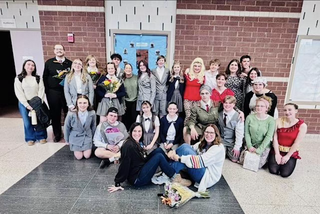 Cast members pose together for a group photo after the production.