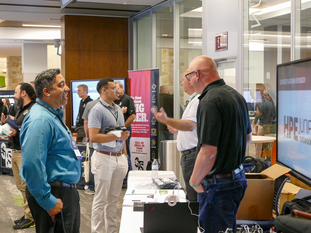 A group of people speaking in a hallway