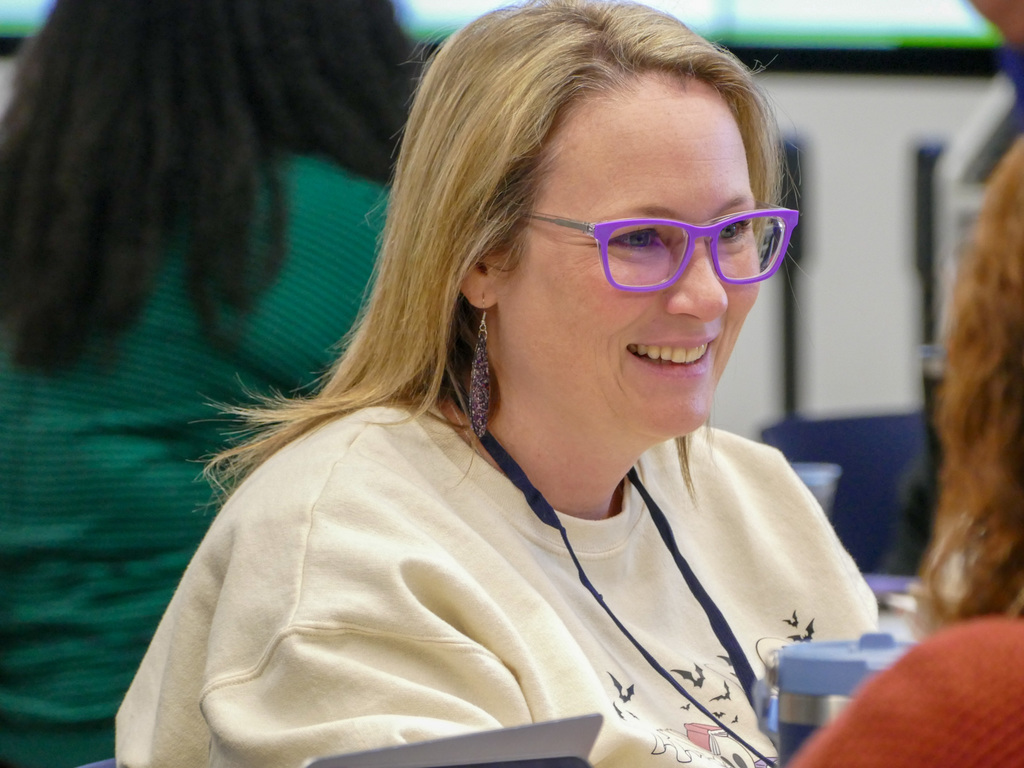 A person in a conference smiling looking at another person