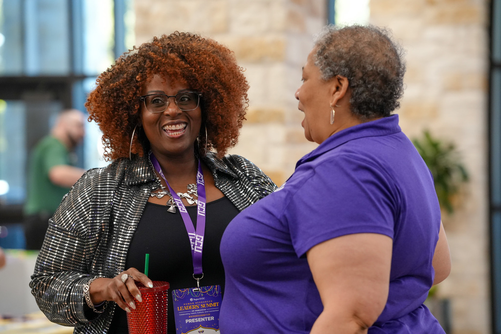 Two women talking and laghing together in an indoor event