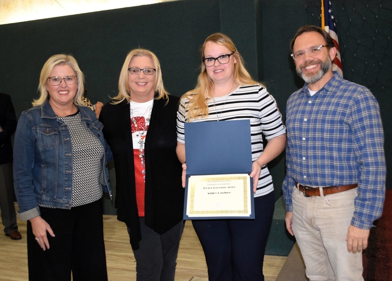 Ashley Gardner being honored at Teacher of the Year. She is in the middle joined with individuals around her. 