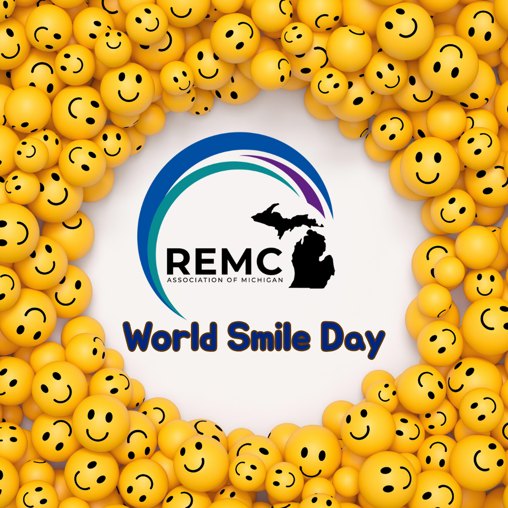 Graphic with a lot of yellow smiley face balls surrounding the REMC Association of Michigan logo in the center. Text reads "World Smile Day" in blue font below the logo.