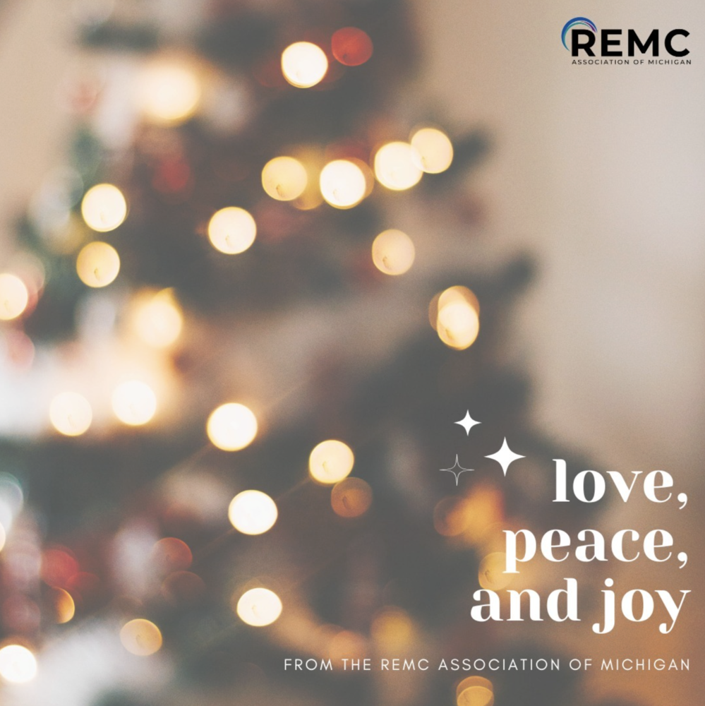 Holiday graphic with a softly blurred background of warm white and gold lights on a Christmas tree. The REMC Association of Michigan logo appears in the top right. Large text reads, “love, peace, and joy,” with smaller text below: “From the REMC Association of Michigan