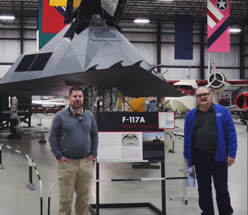 An image of 2 RITS members standing next to a F-117a nighhawk stealth fighter during their tour of the Kalamazoo Air Zoo