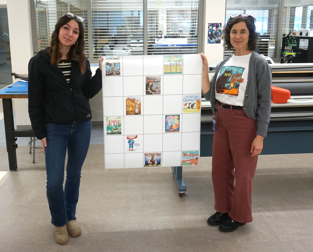 Individuals holding the Chickadee Award Winner Bee Bot coding map