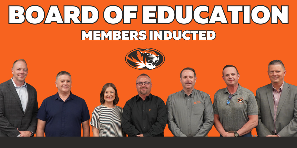 Orange background with letters that read Board of Education Members Inducted, with individuals standing in a group