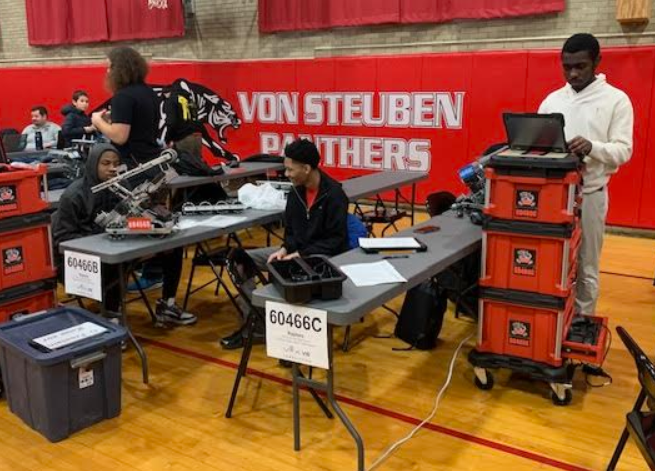 Tyrone, Clarence and Aaron working on code and robot mechanisms.